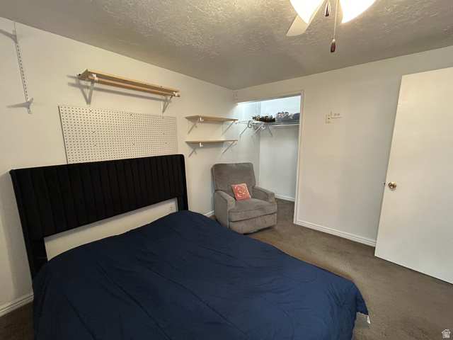 7659 State Street Midvale, UT 84047 - Photo 17 of 33 Bedroom with a textured ceiling, dark carpet, ceiling fan, and a closet
