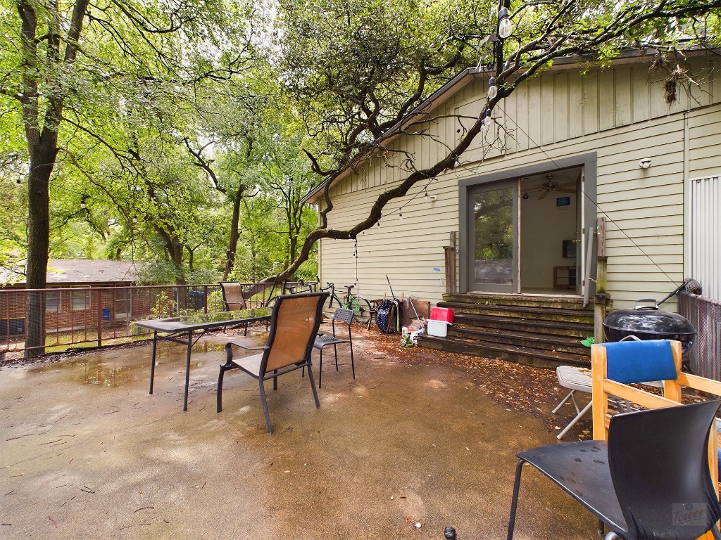 915 Keith Lane, Unit 104 Austin, TX 78705 - Photo 6 of 14 a view of a patio with table and chairs and wooden fence