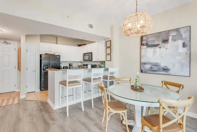 a kitchen with stainless steel appliances kitchen island granite countertop a table and chairs in it