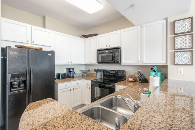 a kitchen with stainless steel appliances granite countertop a refrigerator sink and stove