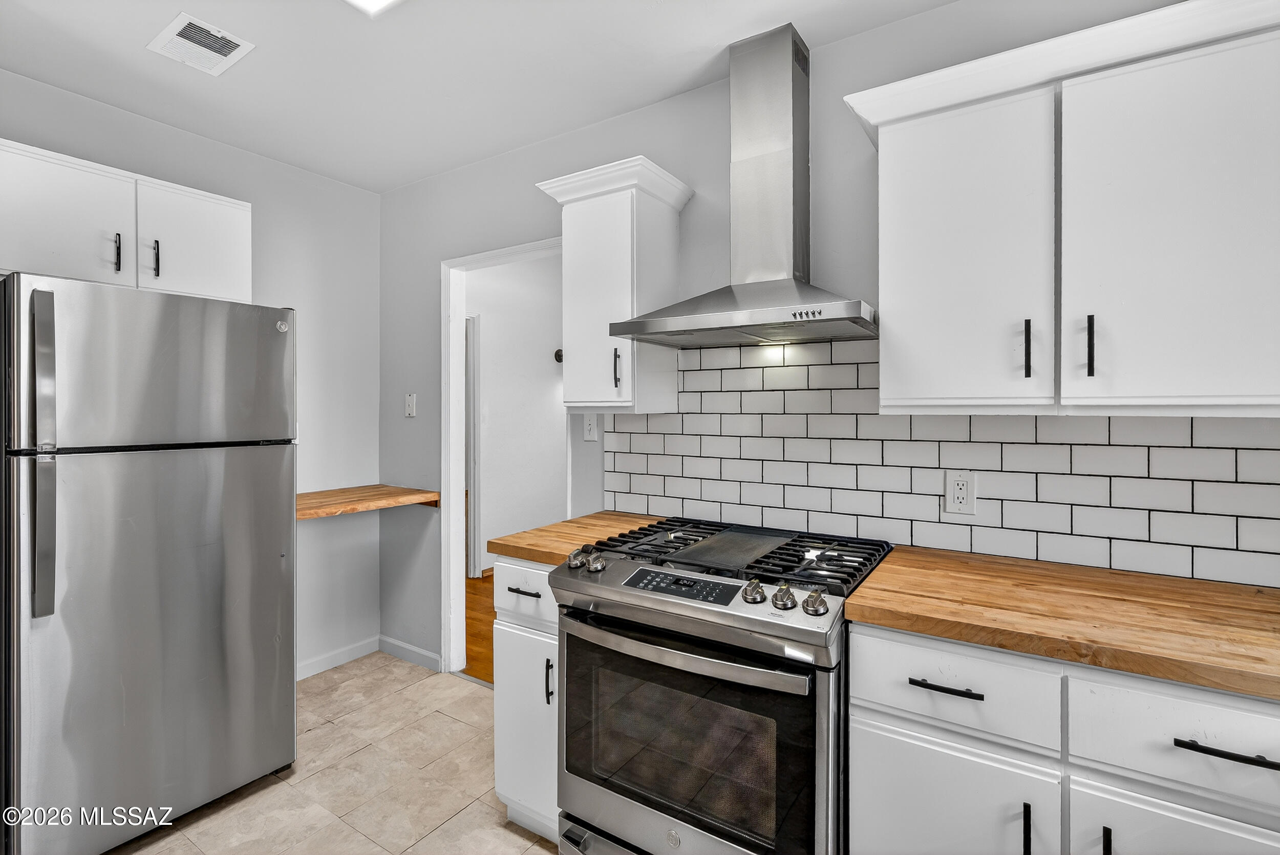 1412 East Spring Street Tucson, AZ 85719 - Photo 16 of 43 a kitchen with stainless steel appliances granite countertop a stove and a refrigerator