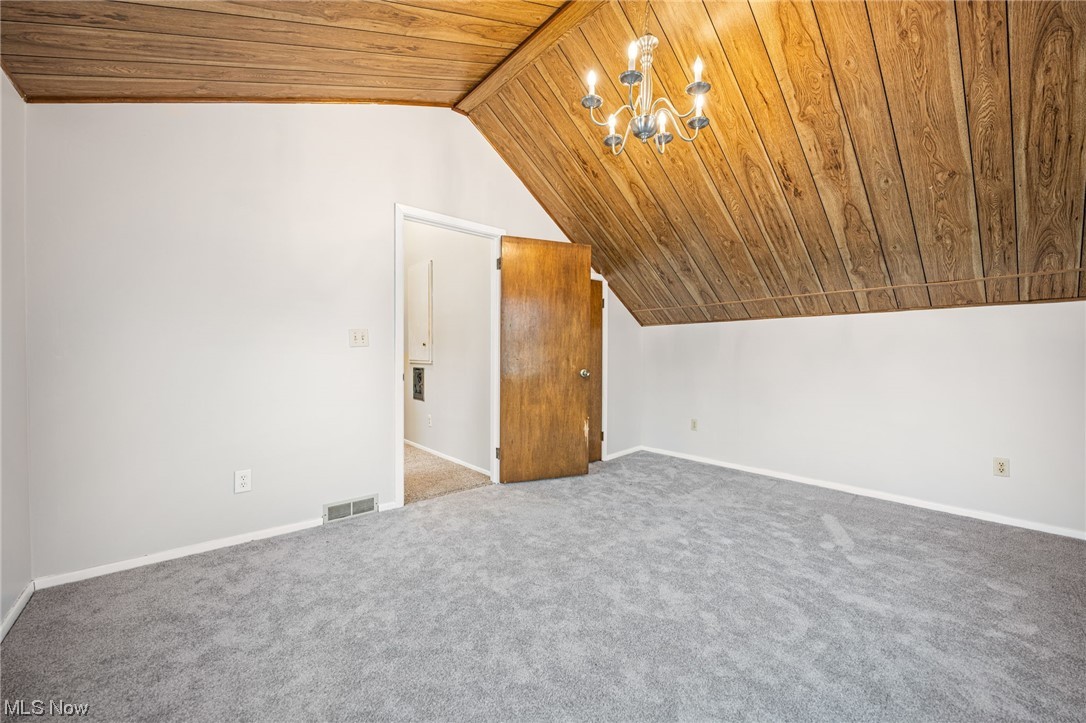 2986 Worrell Road Willoughby, OH 44094 - Photo 25 of 36 Bonus room with light carpet, an inviting chandelier, wooden ceiling, and vaulted ceiling with beams