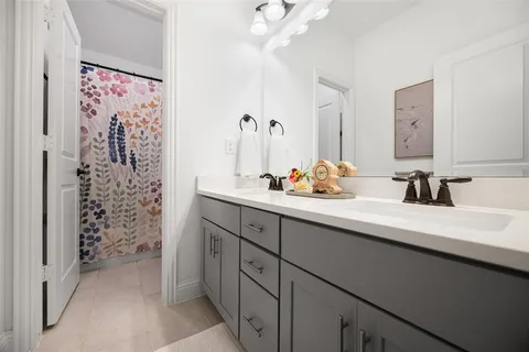 a bathroom with a double vanity sink mirror and shower