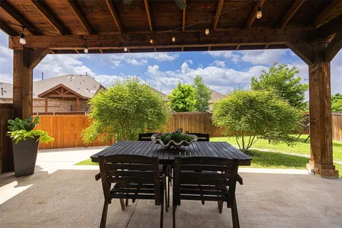 a view of a patio with table and chairs and potted plants