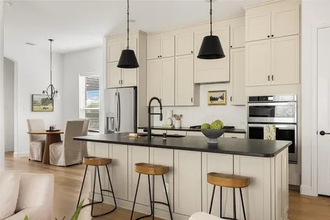 a kitchen with stainless steel appliances kitchen island granite countertop a table and chairs in it