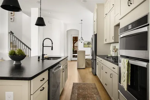 a kitchen with stainless steel appliances a sink a stove and cabinets
