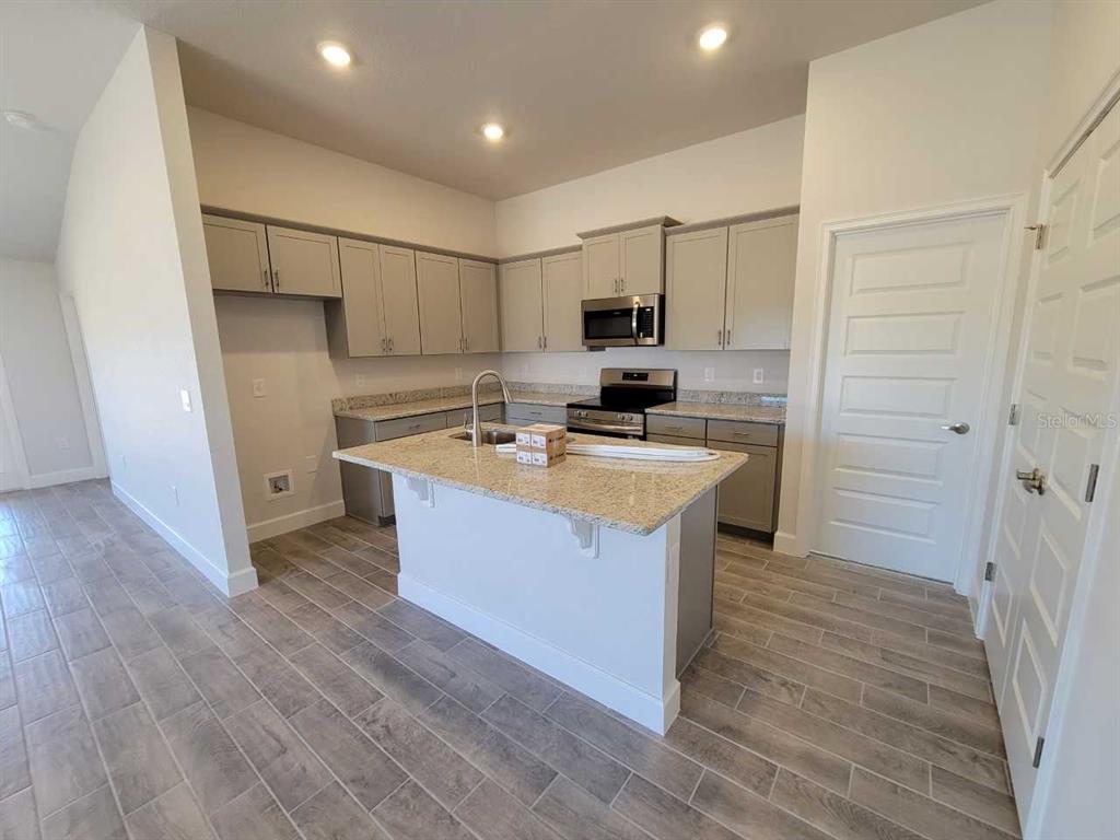 4513 Southwest 91st Ln Road Ocala, FL 34476 - Photo 5 of 36 a kitchen with a sink a counter top space stainless steel appliances and cabinets