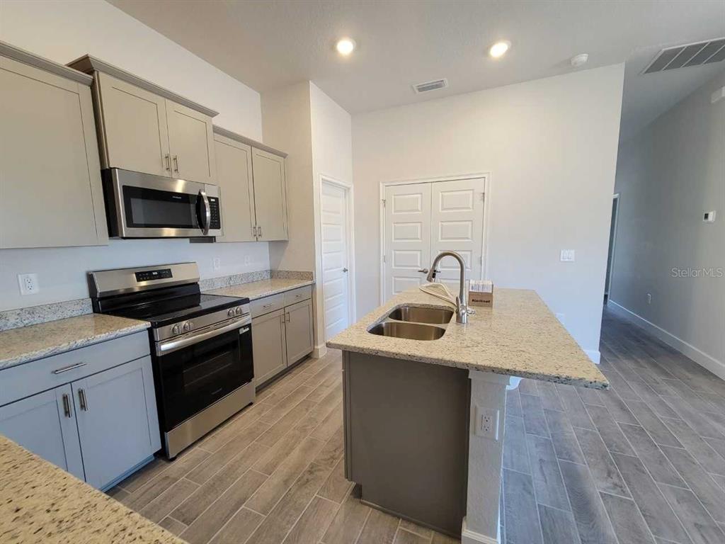 4513 Southwest 91st Ln Road Ocala, FL 34476 - Photo 6 of 36 a kitchen with a sink stove and microwave