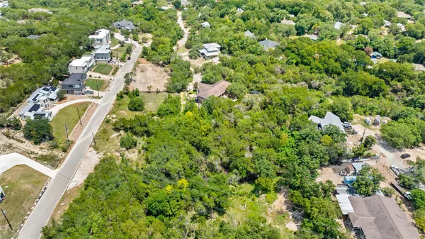an aerial view of residential houses with outdoor space and trees