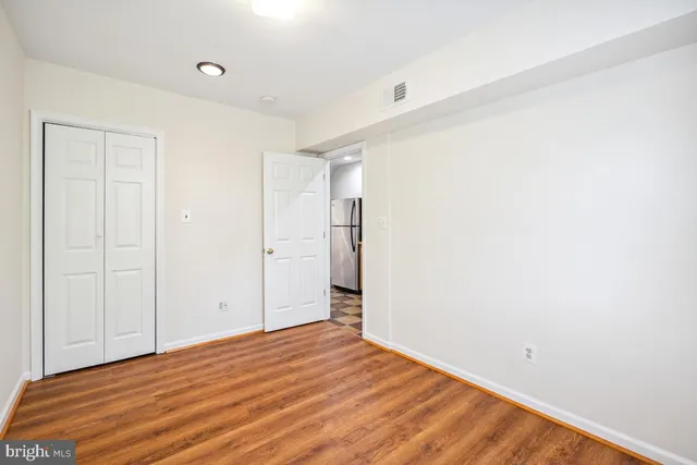 a view of empty room with wooden floor