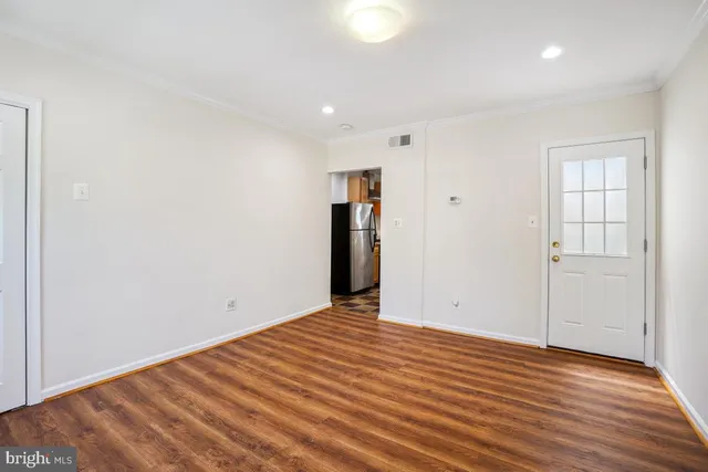 a view of an empty room with wooden floor