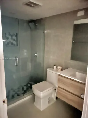 a bathroom with a granite countertop sink a shower and a mirror