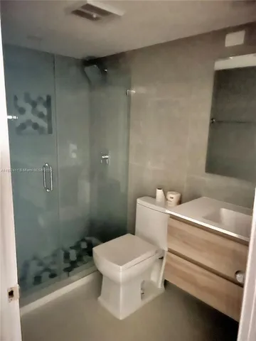 a bathroom with a granite countertop sink a shower and a mirror