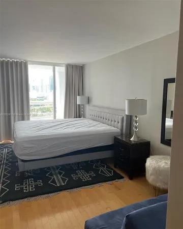 a bedroom with bed cabinet and window