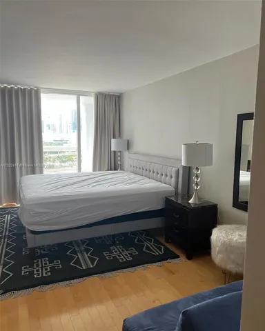 a bedroom with bed cabinet and window