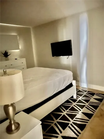 a bedroom with a bed and a potted plant