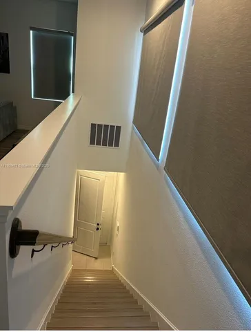 a view of a hallway with wooden floor and staircase