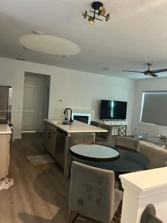 a kitchen with a table chairs and a flat screen tv