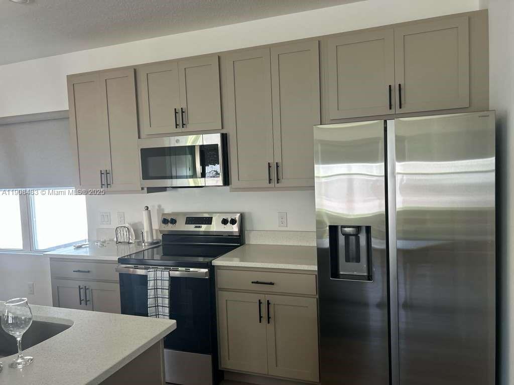 2952 Embark Trail, Unit D134 St. Cloud, FL 34771 - Photo 5 of 12 a kitchen with a sink stainless steel appliances and cabinets