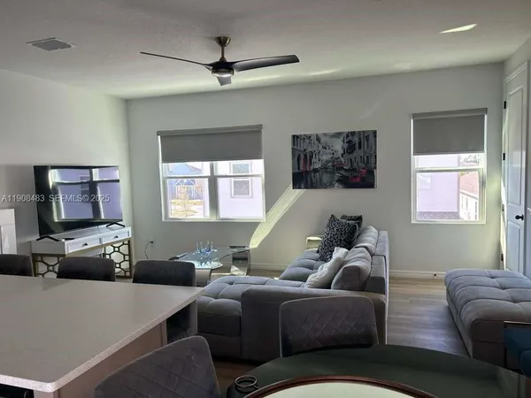 a living room with furniture a window and a flat screen tv