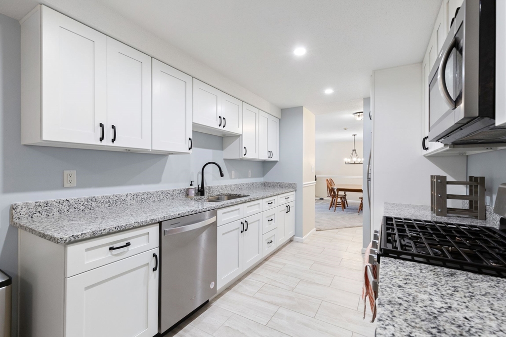a kitchen with stainless steel appliances granite countertop a sink stove and cabinets