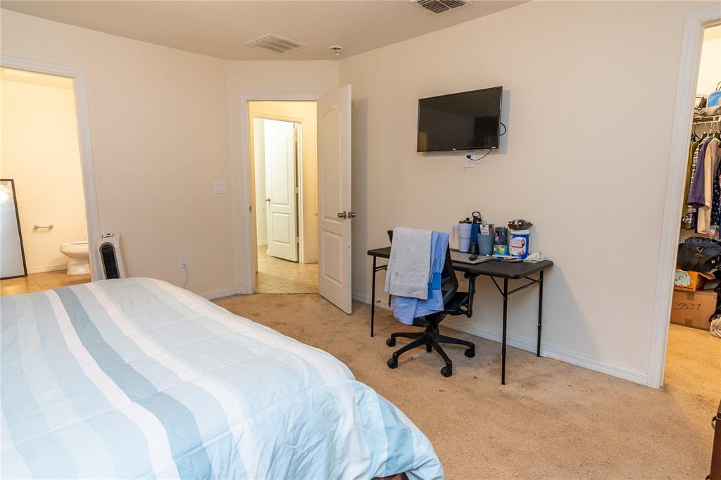 4563 Orchard Grove Road St. Cloud, FL 34772 - Photo 23 of 51 a bedroom with a bed and a flat screen tv