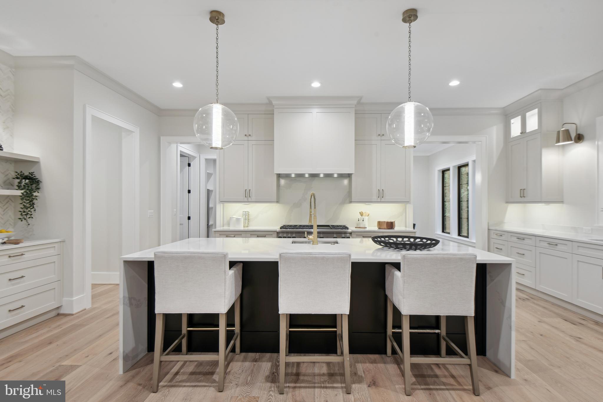 6523 Old Chesterbrook Road McLean, VA 22101 - Photo 3 of 17 a kitchen with stainless steel appliances kitchen island granite countertop a dining table chairs and white cabinets