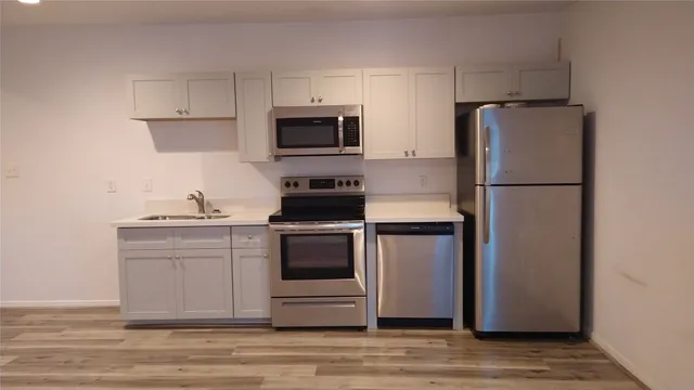 a kitchen with white cabinets and stainless steel appliances