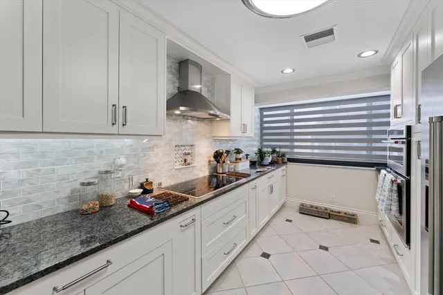 a kitchen with granite countertop white cabinets and white appliances