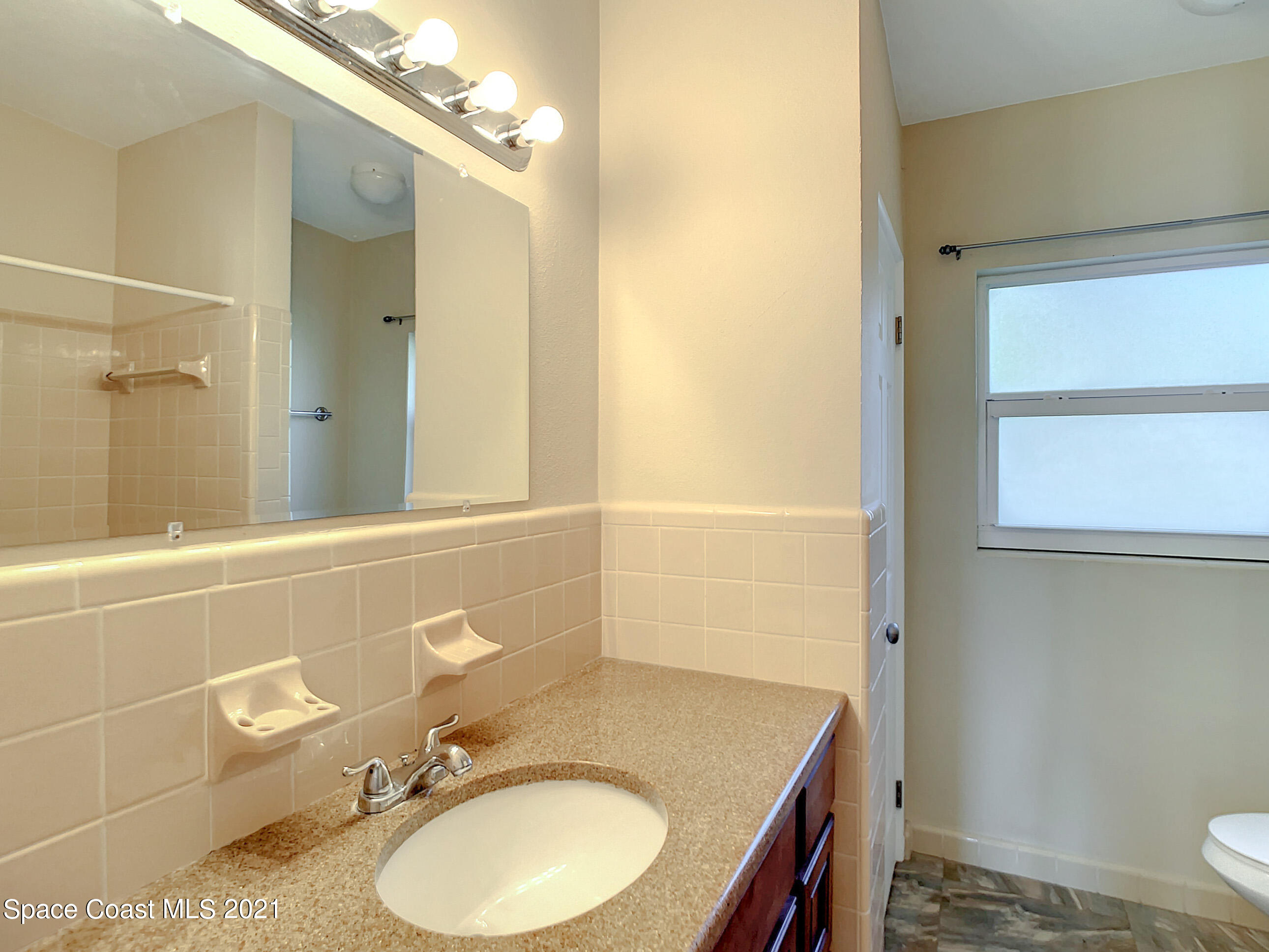 946 Santa Cruz Road Cocoa Beach, FL 32931 - Photo 14 of 26 a bathroom with a granite countertop sink toilet and shower