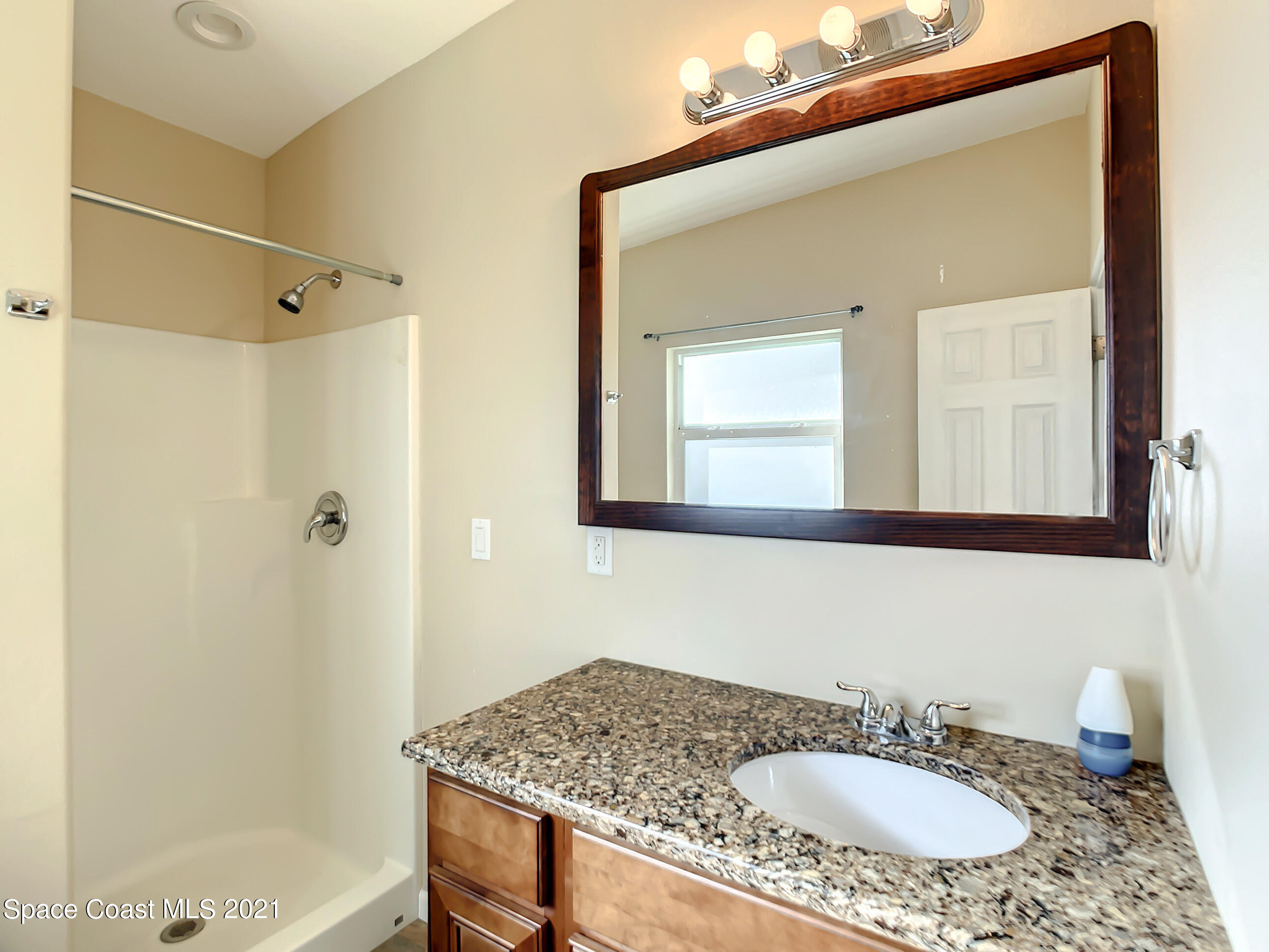 946 Santa Cruz Road Cocoa Beach, FL 32931 - Photo 20 of 26 a bathroom with a granite countertop sink mirror and a bathtub
