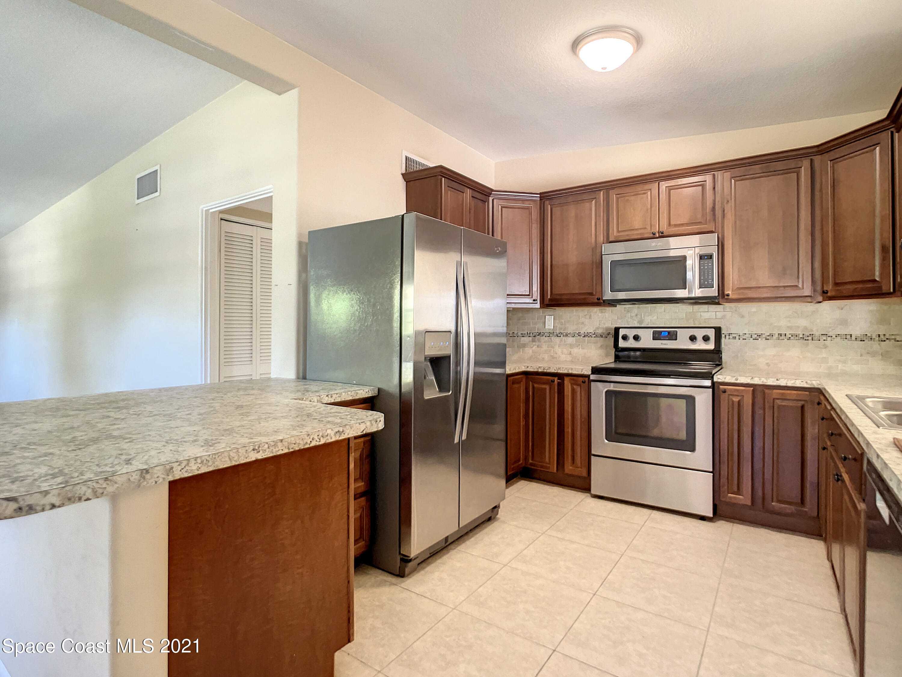 946 Santa Cruz Road Cocoa Beach, FL 32931 - Photo 3 of 26 a kitchen with stainless steel appliances granite countertop a stove refrigerator and a sink