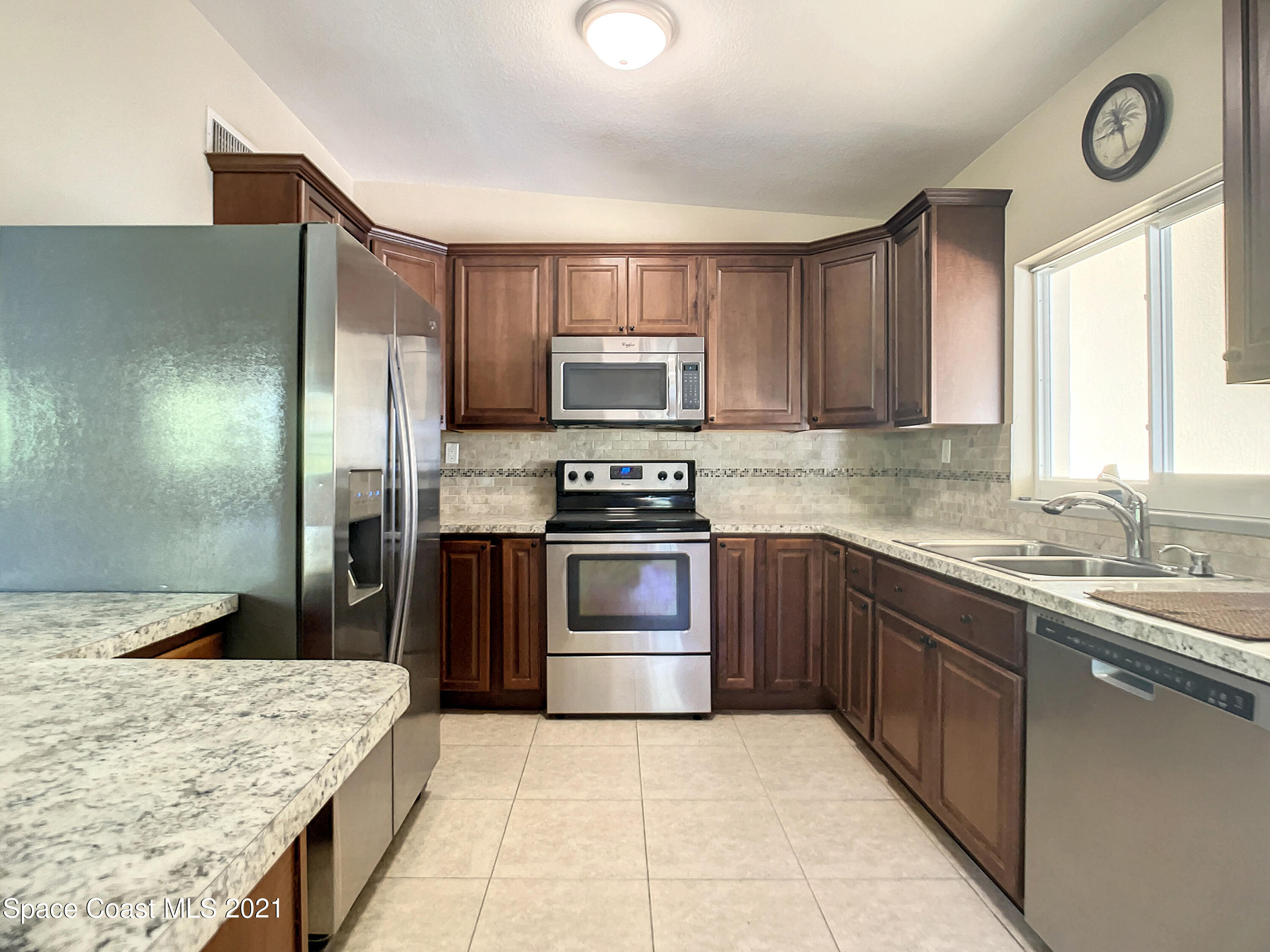 946 Santa Cruz Road Cocoa Beach, FL 32931 - Photo 4 of 26 a kitchen with stainless steel appliances granite countertop a stove a sink and a refrigerator