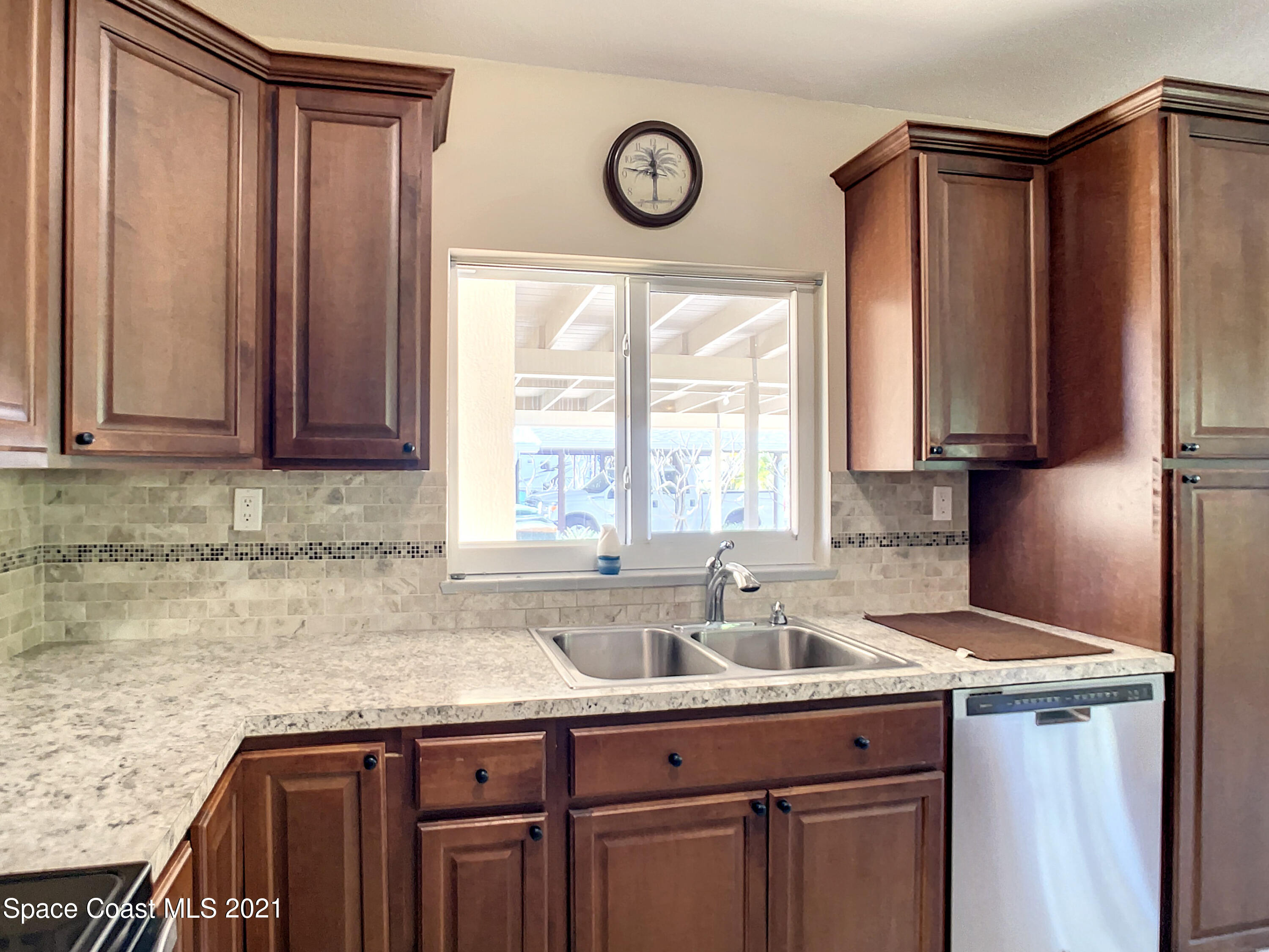 946 Santa Cruz Road Cocoa Beach, FL 32931 - Photo 6 of 26 a kitchen with stainless steel appliances granite countertop a sink a window and cabinets