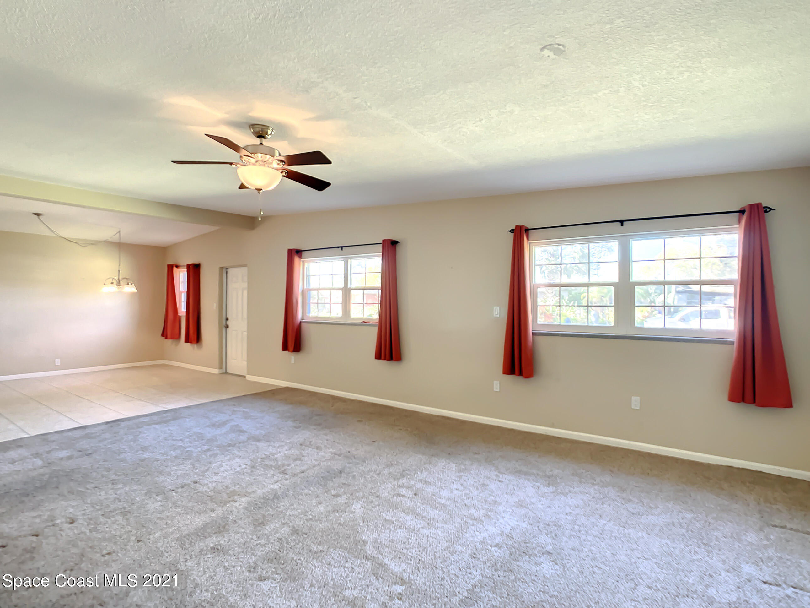 946 Santa Cruz Road Cocoa Beach, FL 32931 - Photo 8 of 26 an empty room with windows and ceiling fan