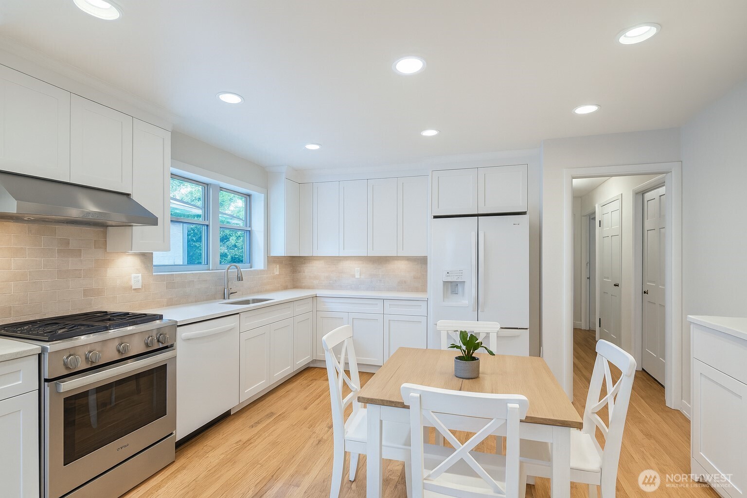 3706 84th Avenue Southeast Mercer Island, WA 98040 - Photo 11 of 38 a kitchen with stainless steel appliances a dining table chairs stove refrigerator and cabinets