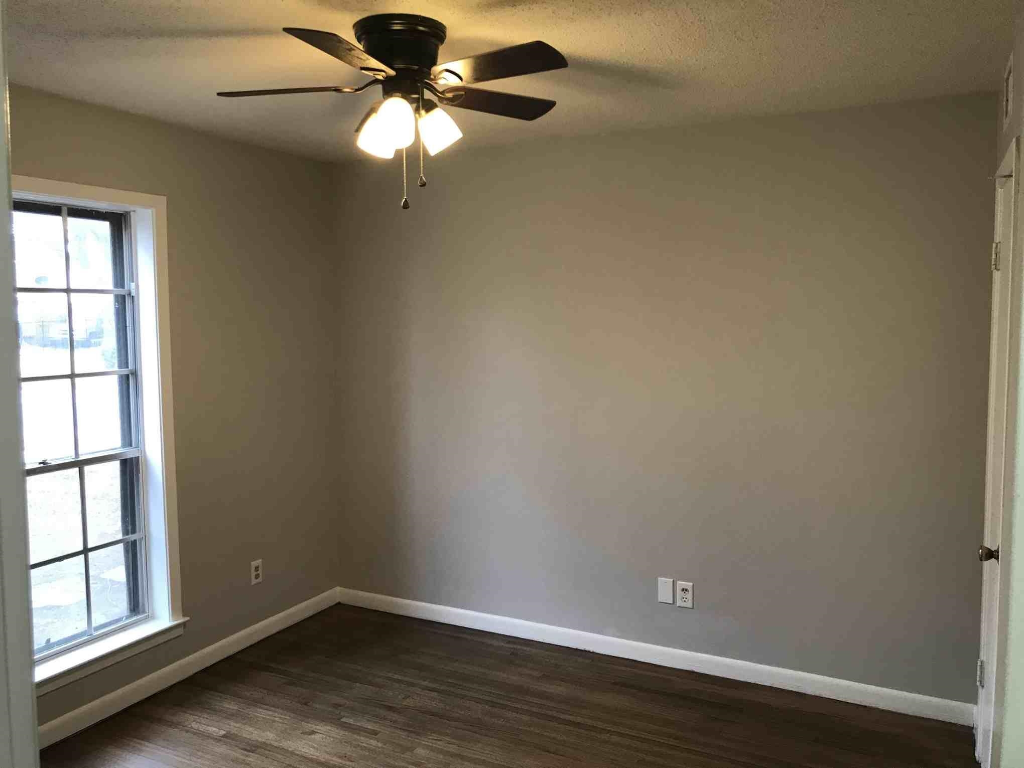 4502 Cottonwood Road Memphis, TN 38118 - Photo 8 of 16 Room with wood-finish flooring, a multi-pane window with white trim, and a ceiling fan with integrated lighting