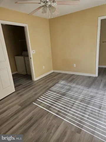 a view of a room with wooden floor and fan