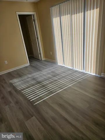 a view of a room with wooden floor and a floor to ceiling window