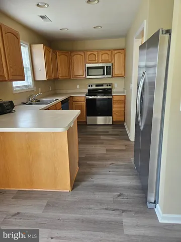 a kitchen with wooden cabinets a refrigerator and a sink