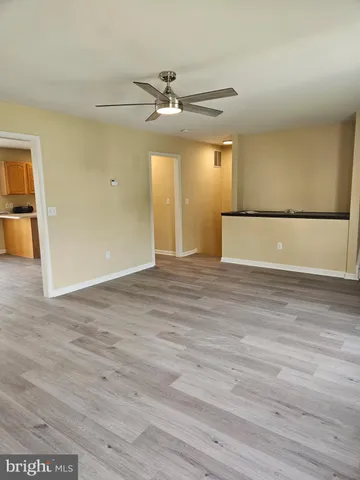 a view of empty room with wooden floor