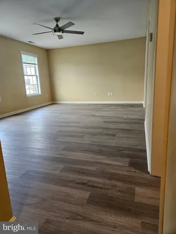 a view of empty room with window and wooden floor