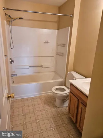 a bathroom with a granite countertop bathtub shower and toilet
