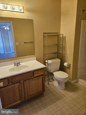 a bathroom with a toilet a sink and mirror