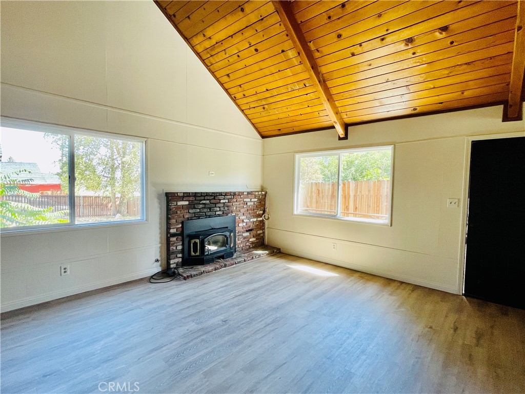 4225 Alcot Trail Frazier Park, CA 93225 - Photo 15 of 31 an empty room with windows a fireplace and wooden floor