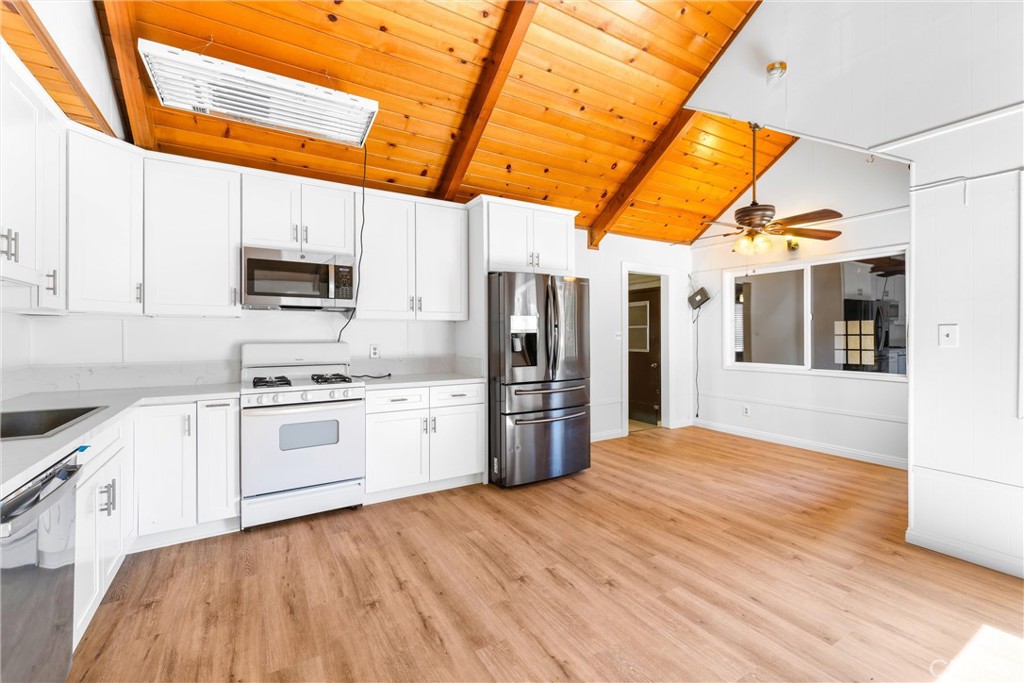 4225 Alcot Trail Frazier Park, CA 93225 - Photo 2 of 31 a kitchen with stainless steel appliances a stove top oven a sink dishwasher and a refrigerator with wooden floor