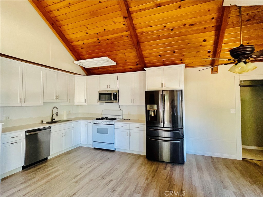 4225 Alcot Trail Frazier Park, CA 93225 - Photo 30 of 31 a kitchen with stainless steel appliances a refrigerator a sink and wooden floors
