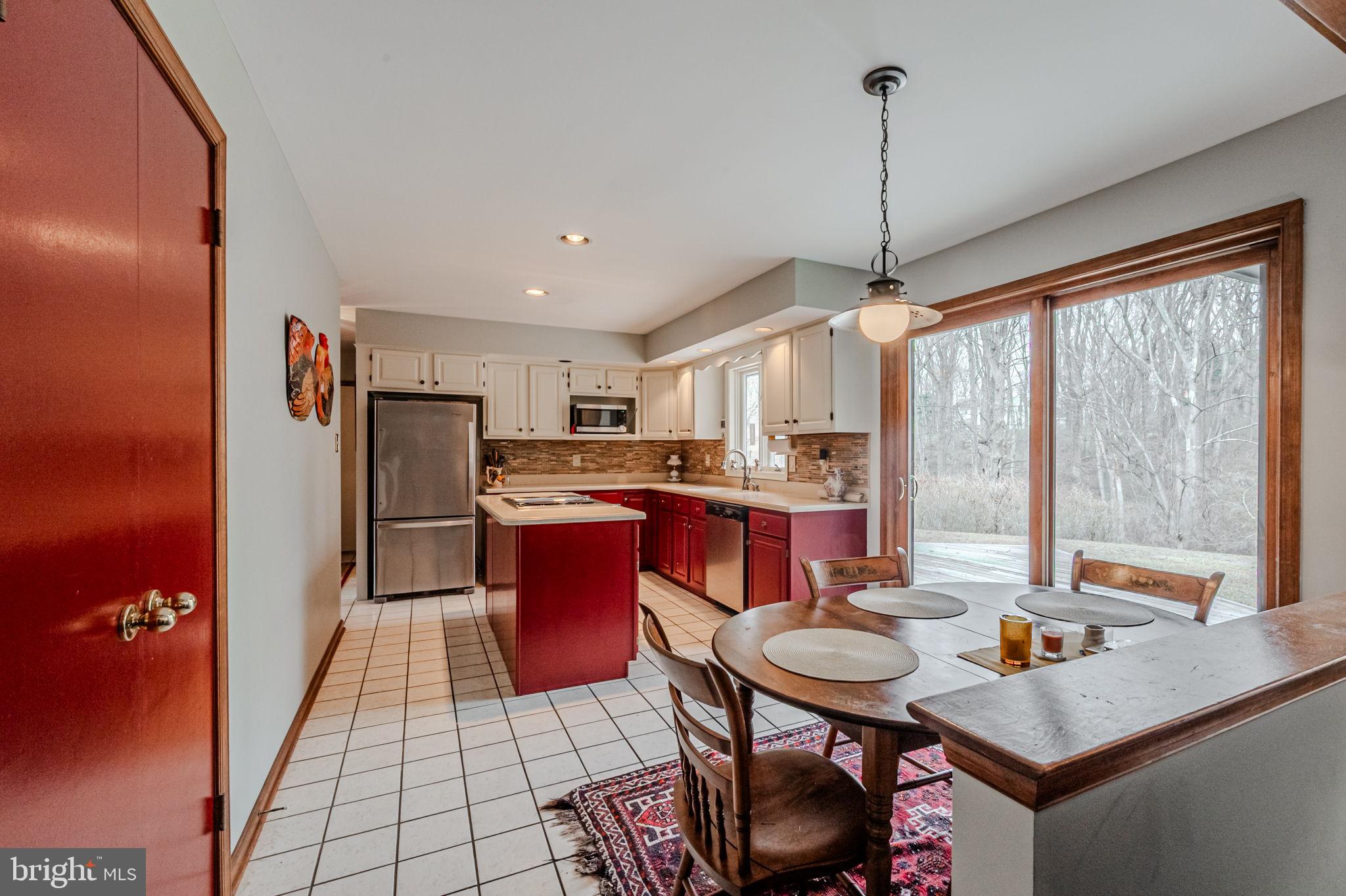53 Bullock Road Chadds Ford, PA 19317 - Photo 13 of 65 a kitchen with stainless steel appliances granite countertop a refrigerator a sink dishwasher a dining table and chairs with wooden floor