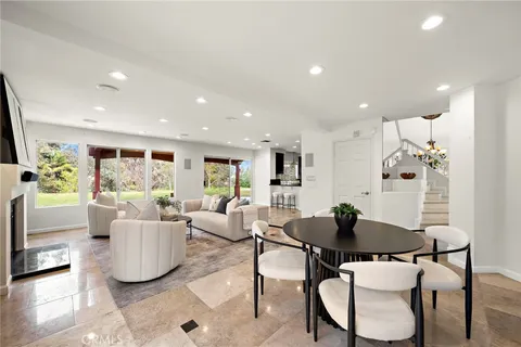 a living room with furniture a fireplace and a large window