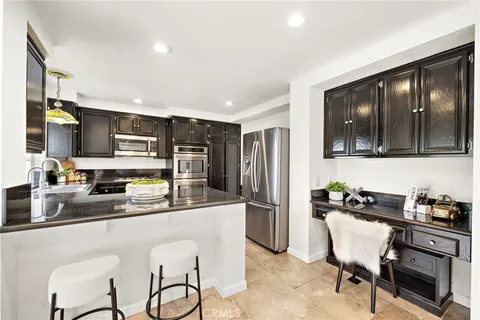 a kitchen with granite countertop stainless steel appliances and window